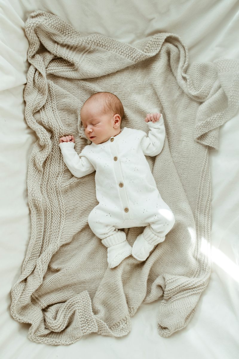 Newborn sleeping on a knit blanket