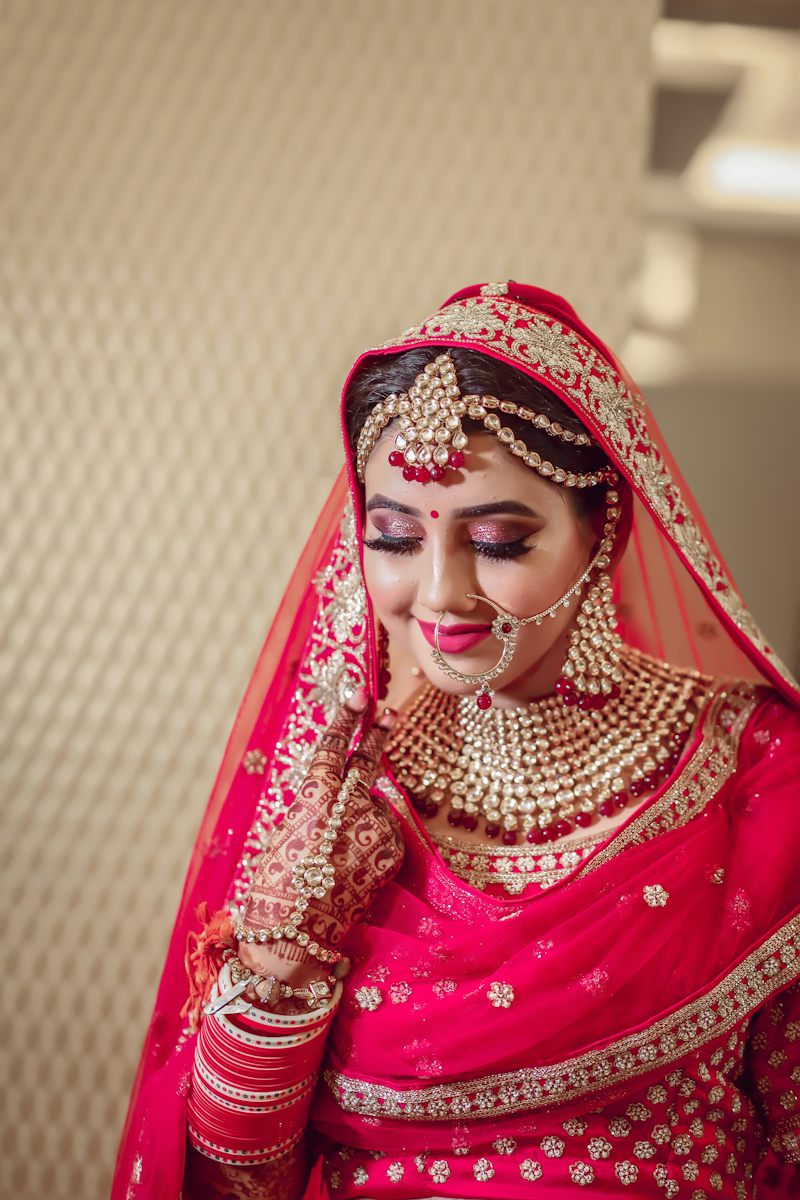 Bride in red lehenga with gold jewellery