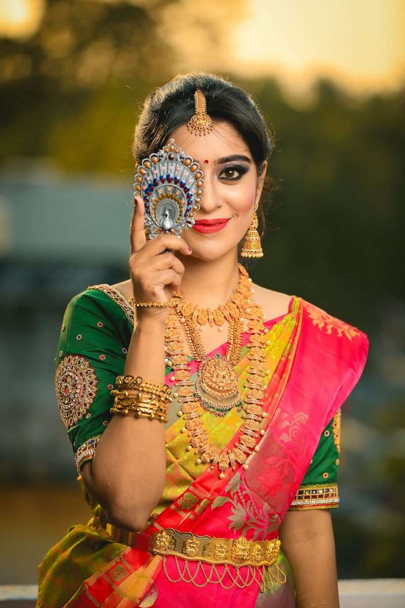 Girl in a half-saree holding a mirror
